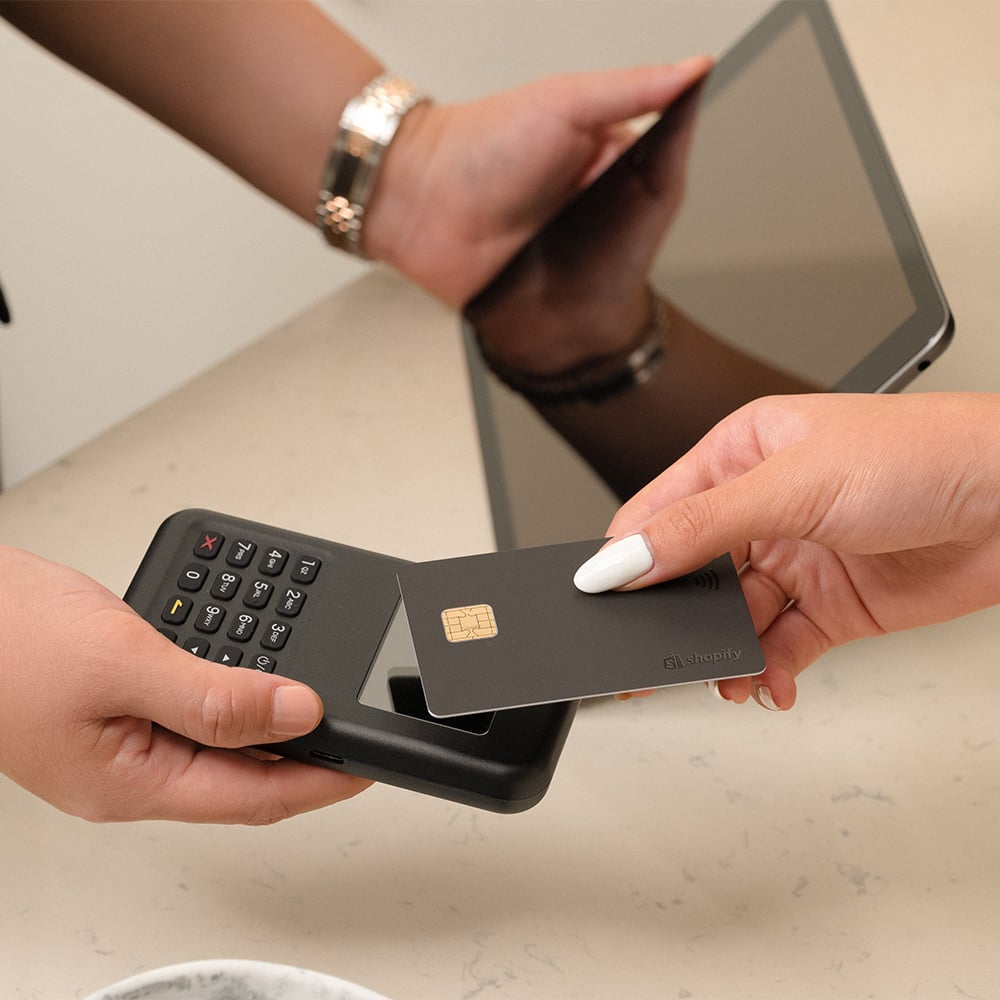 A customer taps their credit card on a modern POS machine to complete a purchase, demonstrating a seamless in-person checkout experience.