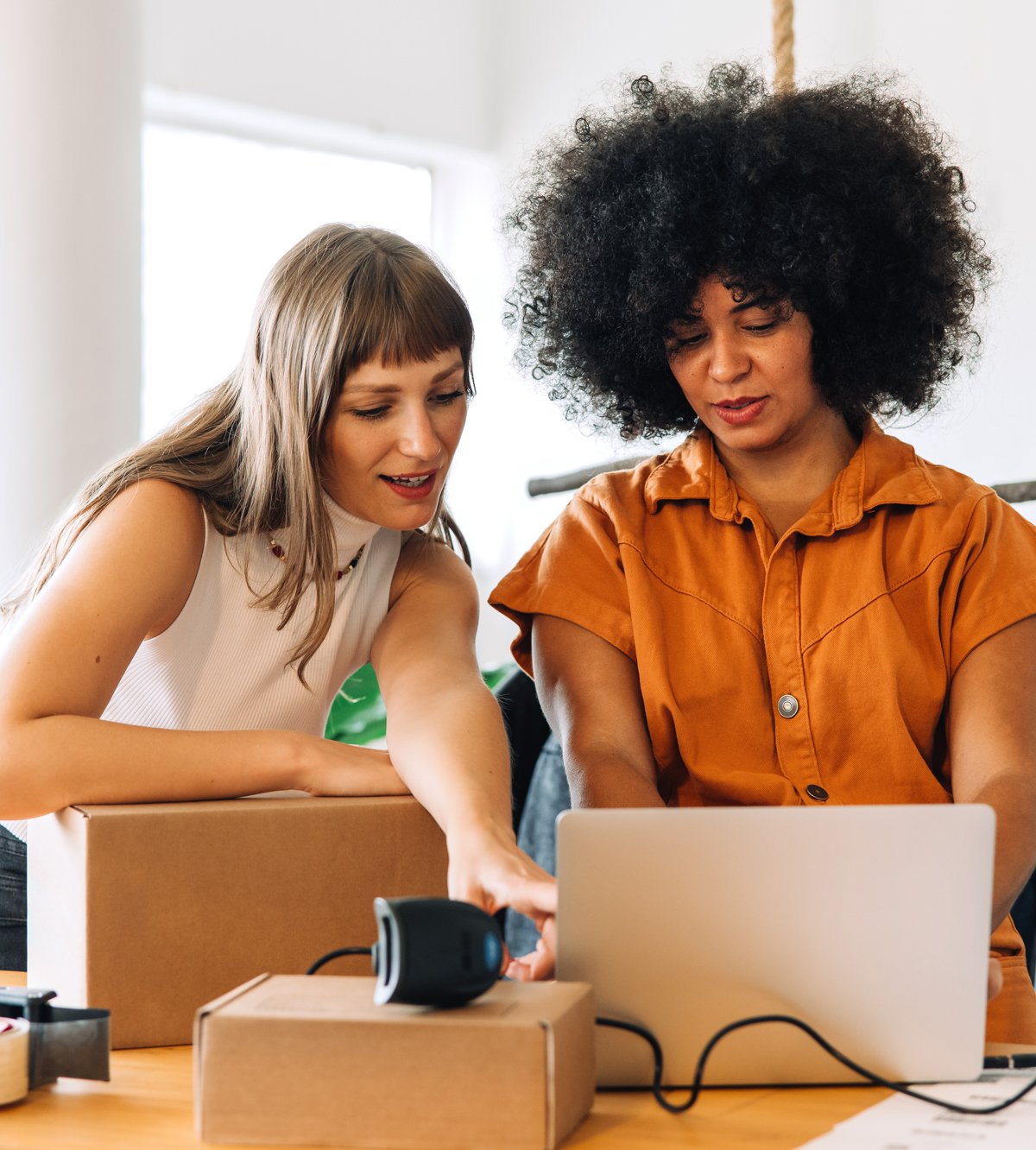 Shopify support specialist provides hands-on guidance to a female business owner on her laptop